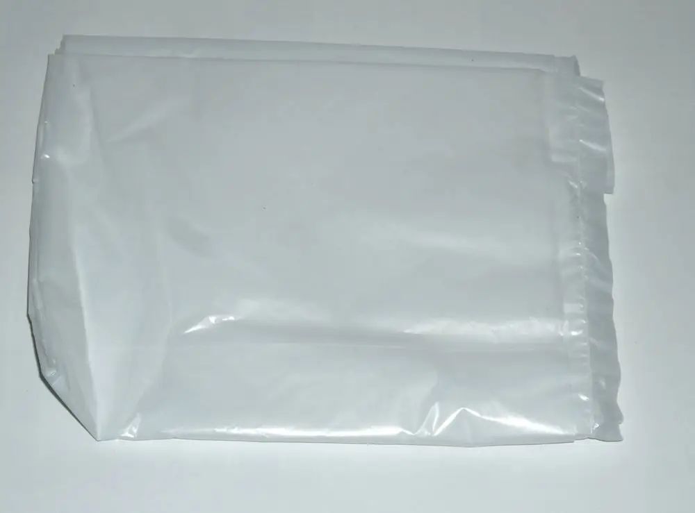 Weiße Kunststoffverpackung, möglicherweise ein Schutzcover oder eine Abdeckung, zur Verwendung mit Daikin Produkten, auf glatter Oberfläche liegend.
